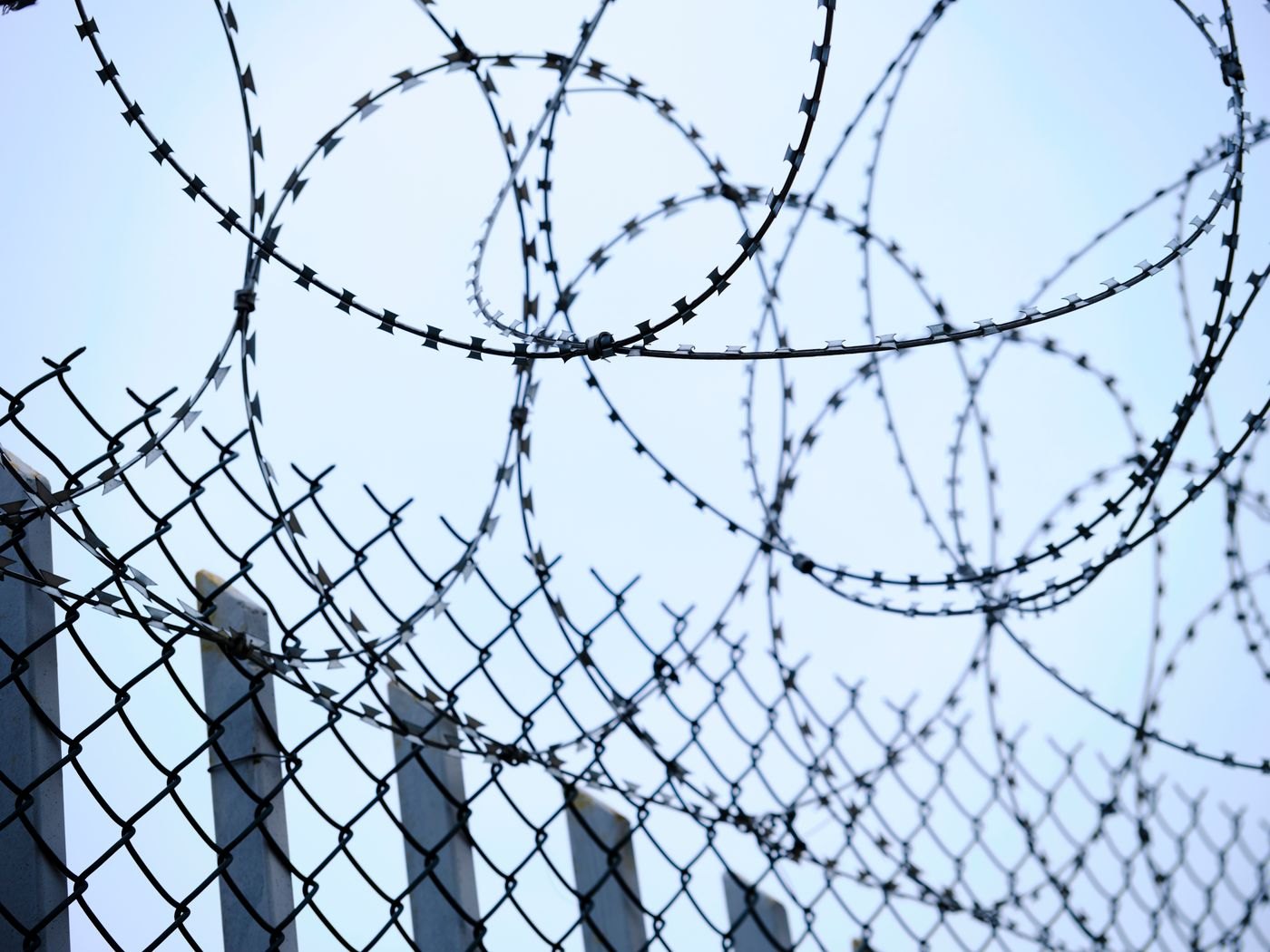 Chain-link fencing and barbed wire form a physical perimeter boundary.