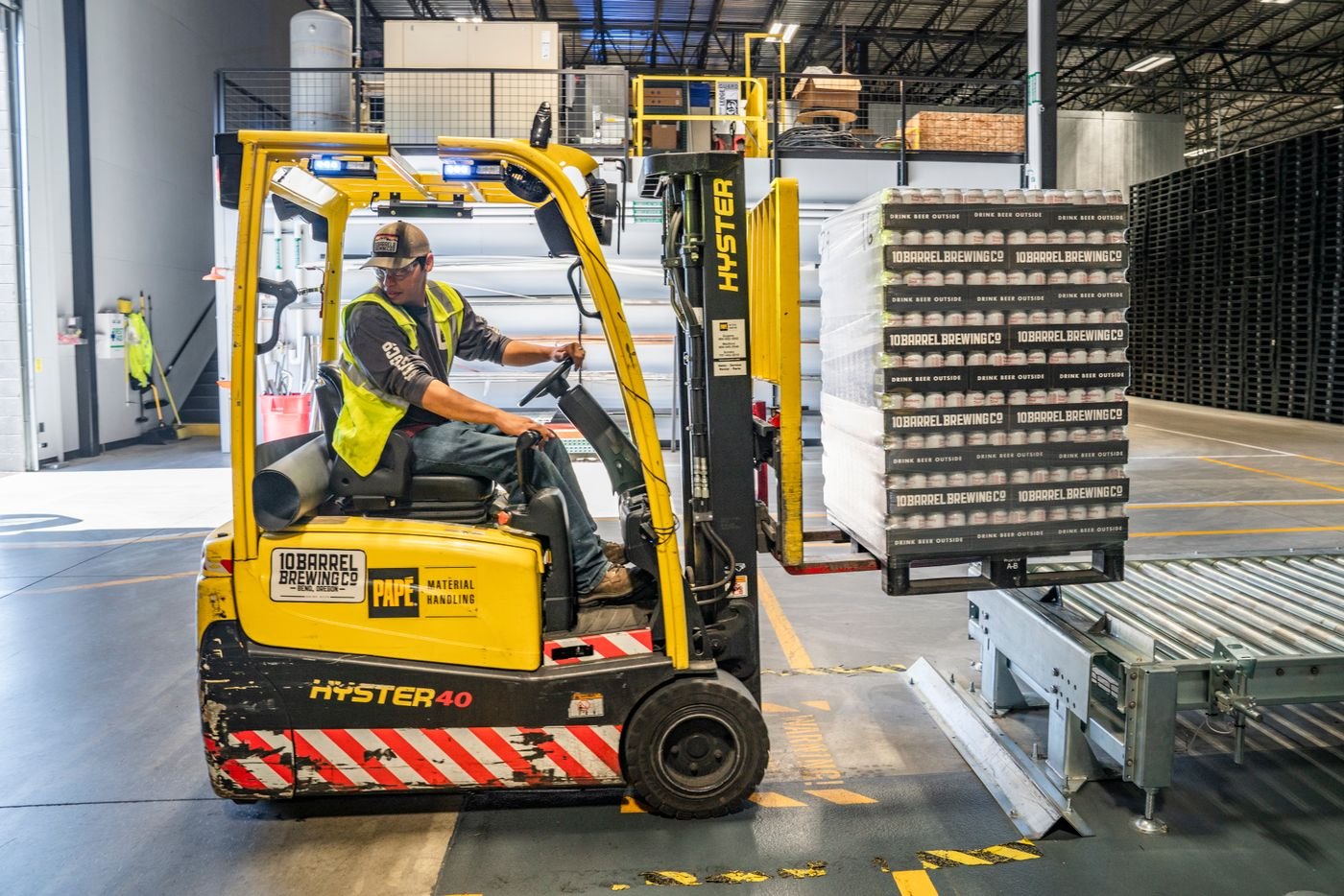 A forklift moves packaged goods through a warehouse.